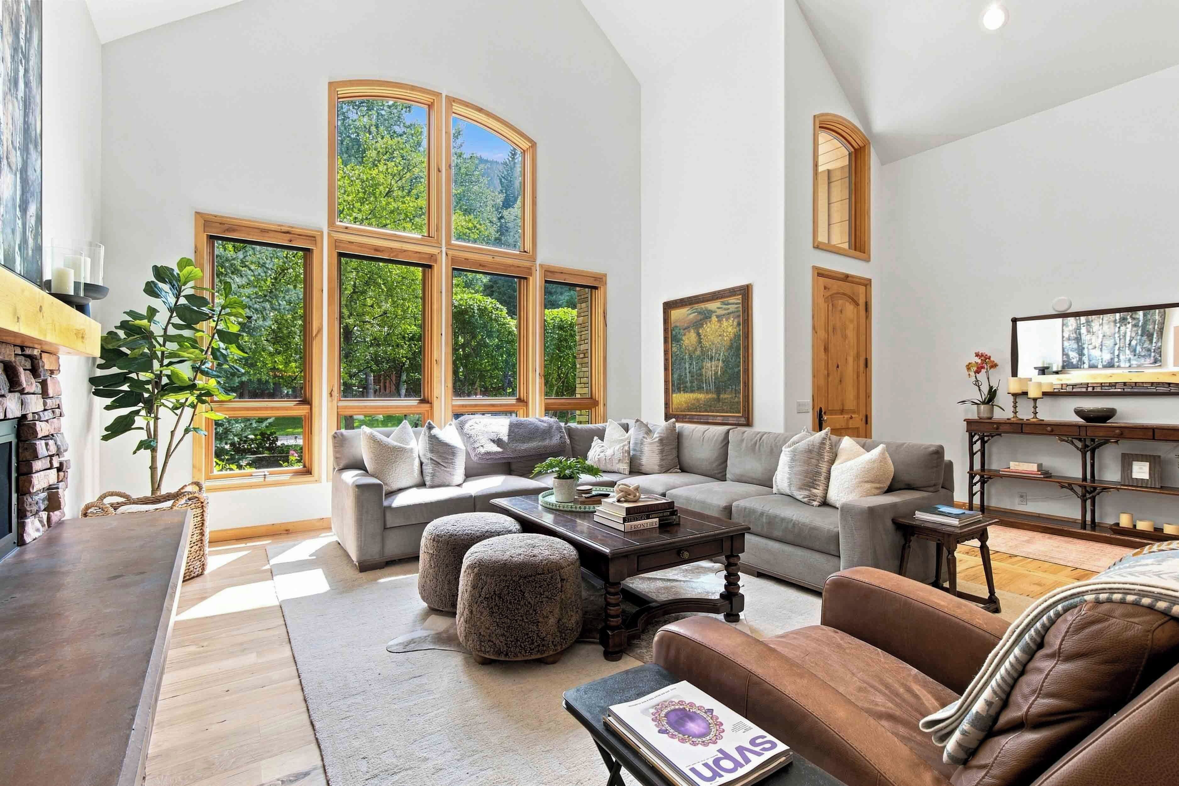 A spacious living room with a large window, a fireplace, and a cozy seating area.