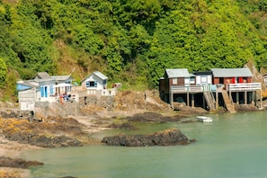 A coastal area with several small buildings, some with steps leading into the water, and a boat in the foreground. - 3-bedroom house in Saint-Brieuc, comfort and quiet (Saint-Brieuc)