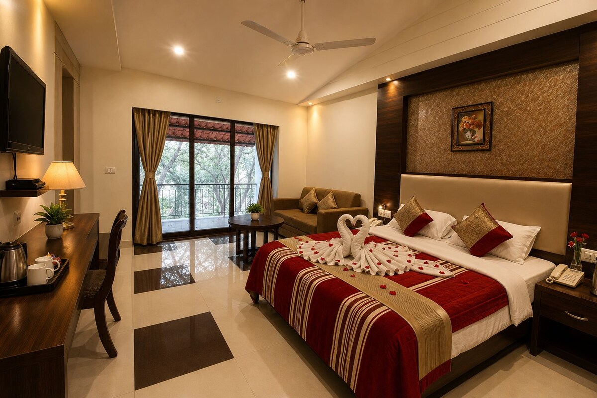 A hotel room with a bed, a desk, a sofa, and a balcony.