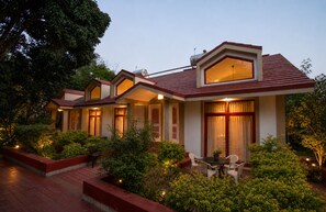 A hotel with multiple guest rooms, a landscaped garden, and outdoor seating. - Ushaascot (Matheran)