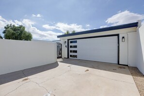 A residential garage with a white door, a black garage door opener, and a concrete driveway. - Walk to Wigwam Resort! Family & Golfer’s Oasis (Litchfield Park)