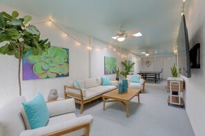 Ein modernes Wohnzimmer mit einer Couch, einem Couchtisch und Zierpflanzen.