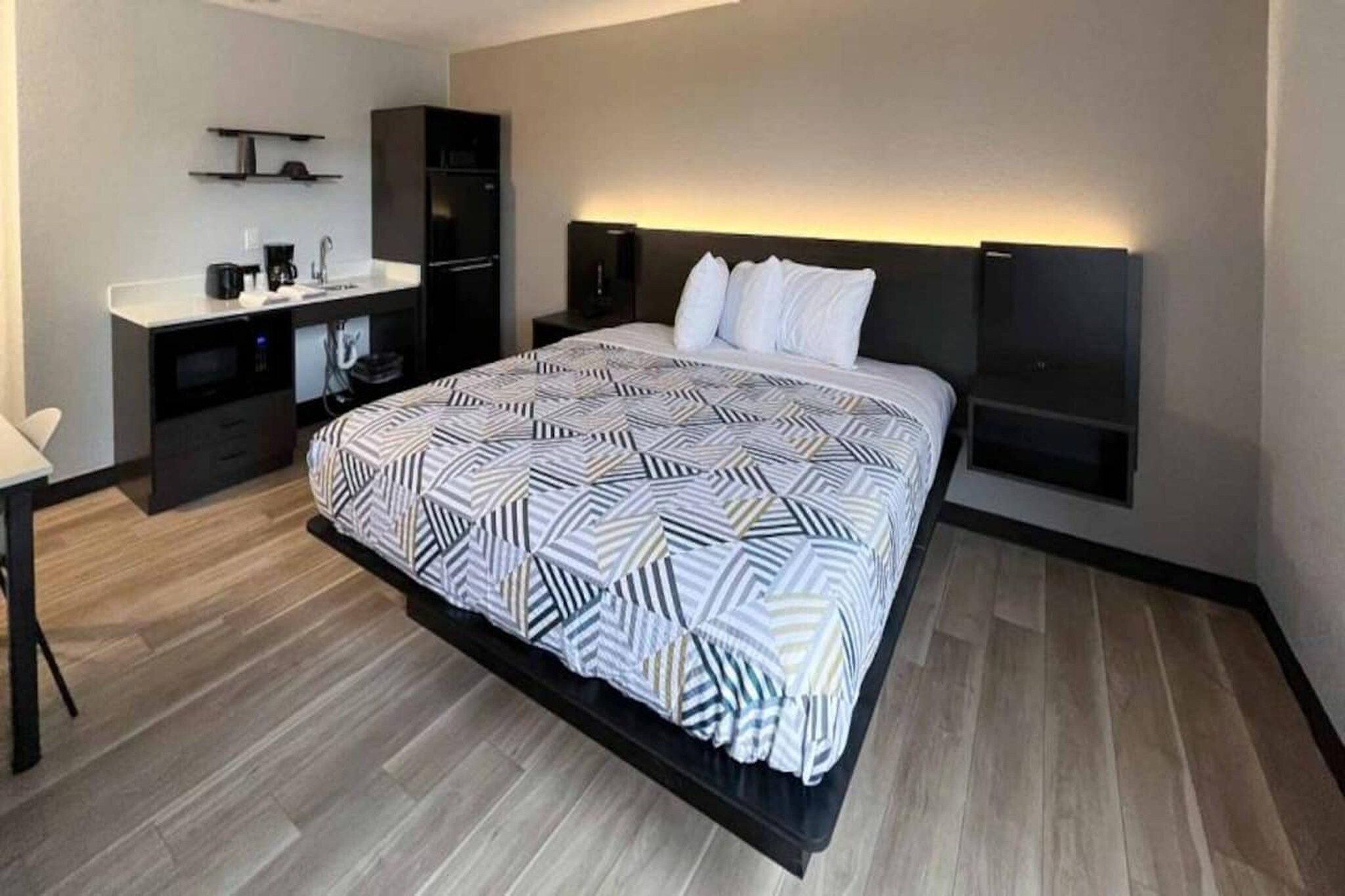 Une chambre d’hôtel moderne dotée d’un grand lit, d’un bureau et d’une armoire intégrée.
