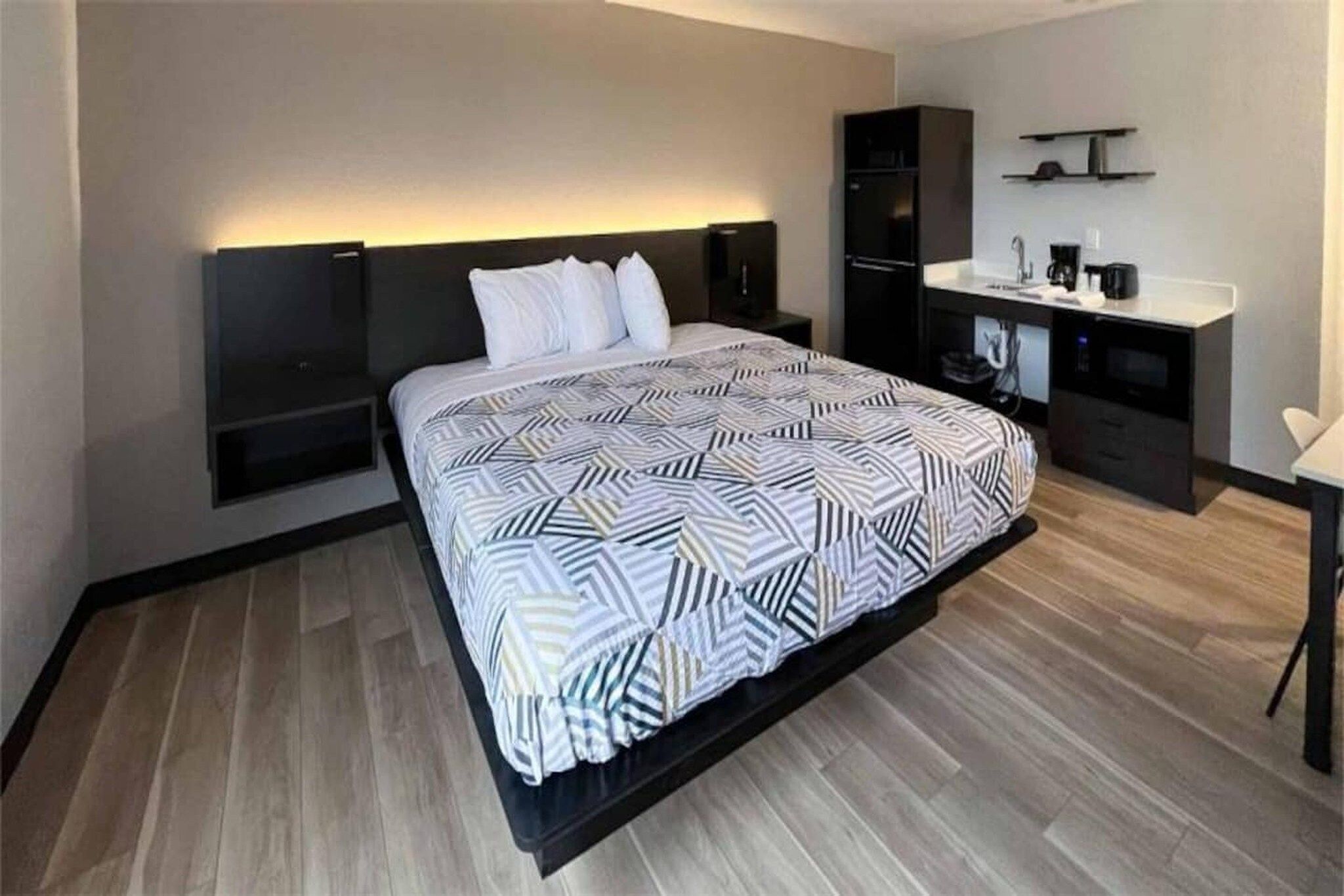 Une chambre à coucher moderne, comprenant un lit, des tables de chevet, un bureau et une armoire intégrée.