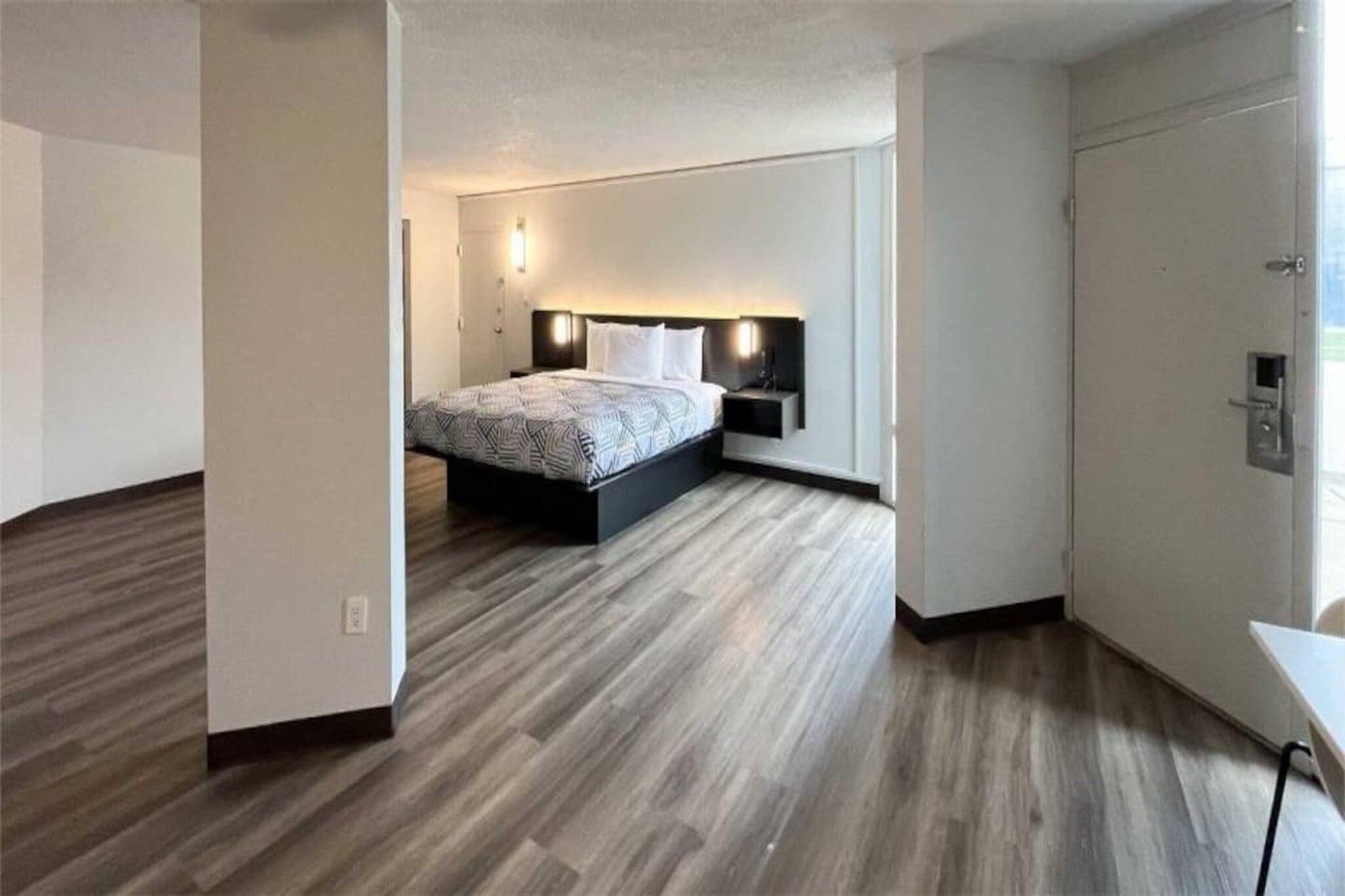 A bedroom with a bed, bedside tables, and a wardrobe.