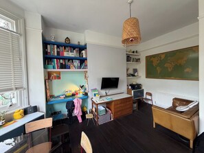 A room with a desk, chair, bookshelf, television, and a map on the wall. - Characterful 1BDR Flat with Desk in Brixton Hill (London)