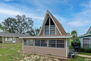 A single-story house with a gabled roof, large windows, and a small porch area. - Flip Flop Cottage: Lake Access in Clermont (Clermont)