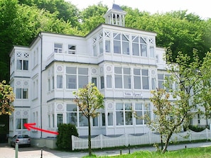 Ein mehrgeschossiges Gebäude mit weißer Fassade, Balkonen und einem Schild, auf dem 'Villa Agnes' steht.