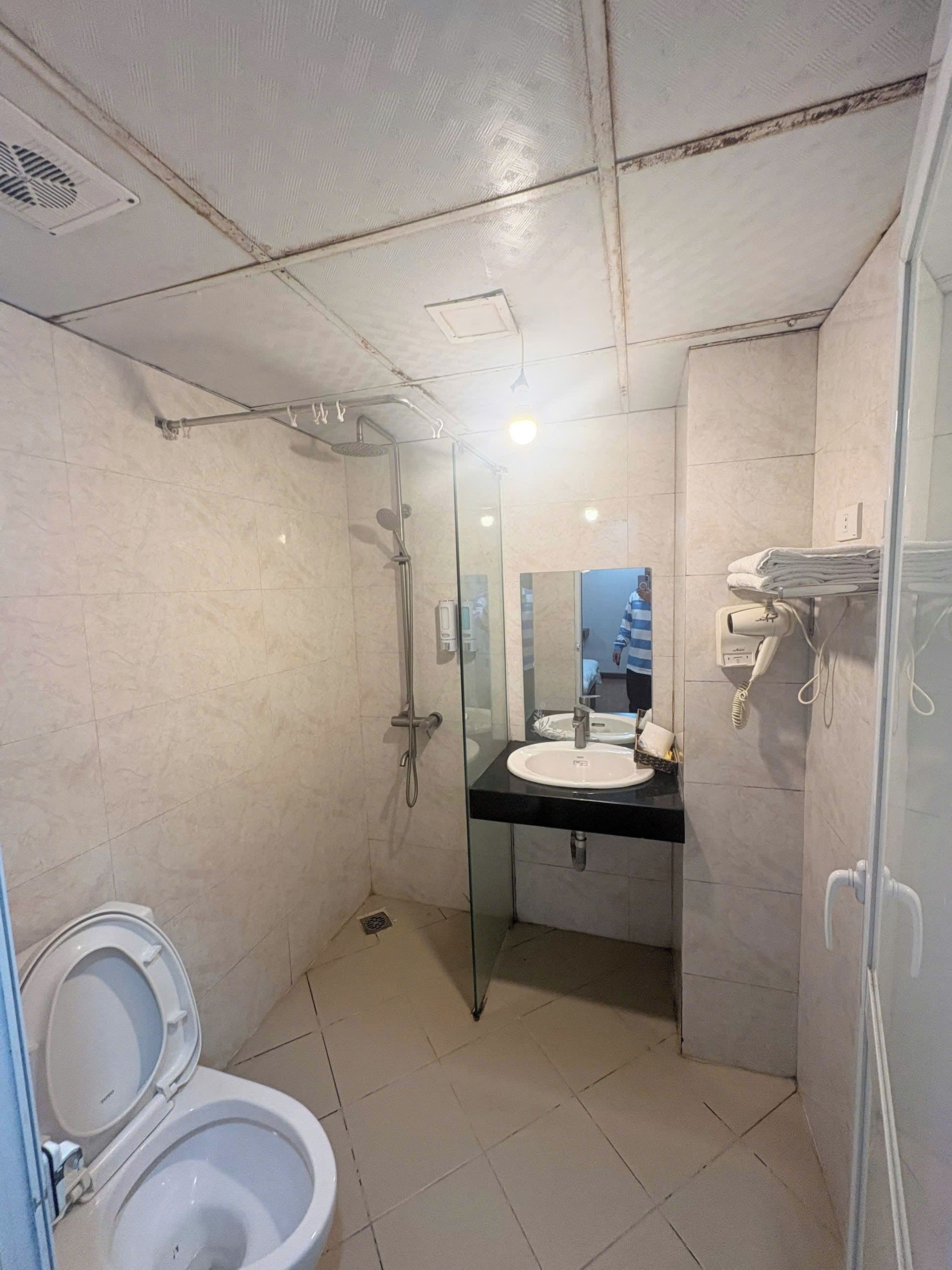 Une salle de bain avec des toilettes, un lavabo et une douche.