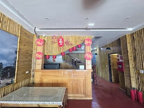 A hotel room with a wooden interior, a table with a patterned tablecloth, and red lanterns. - Nexus Hotel (Sa Pa)