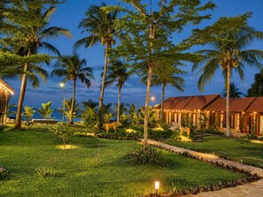 A resort with multiple buildings, palm trees, and a well-maintained lawn.