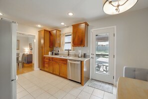 A modern kitchen with wooden cabinets, a dishwasher, and a large window. - Walk to Expo Square: 4 Mi to Dtwn Tulsa (Tulsa)