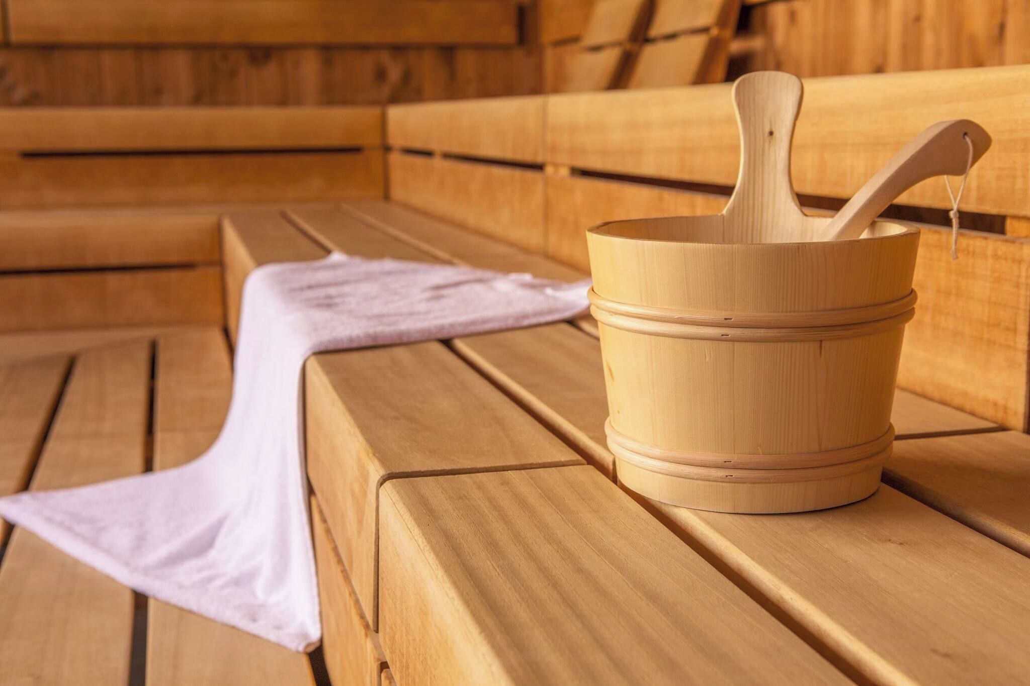 A wooden bench with a wooden bucket and a wooden mallet on it.