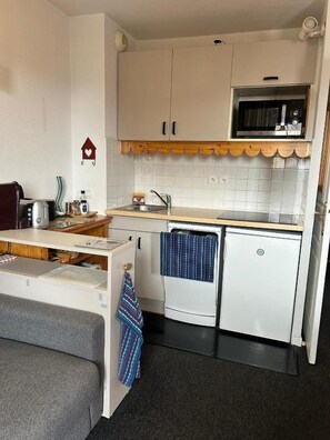 A compact kitchenette with a microwave, a sink, and a small refrigerator. - Risoul 1850 • Apartment for 4–5 people • Skis on your feet • Swimming Pool & Sauna (Risoul)