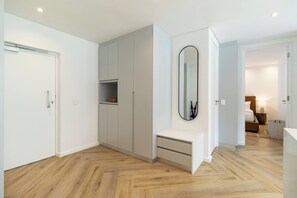 A modern room with built-in wardrobes, a bench, and a mirror. - Modern luxury Claremont apartment - sleeps 6 (Cape Town)