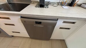 A kitchen with a dishwasher, a sink, and a countertop with various items. - Beautiful 2 bedroom terrace and parking (Cannes)