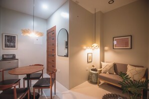 Ein modernes Wohnzimmer mit Essbereich, ausgestattet mit einem Holztisch, Stühlen, einer Couch und einem Couchtisch.