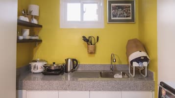 Una cocina compacta con ventana, pileta y estufa.