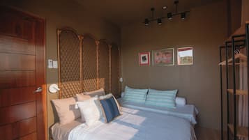 Un dormitorio con cama, una puerta de madera, una lámpara de pared y un accesorio de luz en el techo.