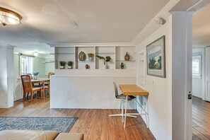 A modern kitchen with wooden flooring, white walls, and a built-in shelf with decorative items. - 3 Mi to Dtwn! Cozy Tampa Home Base (Tampa)