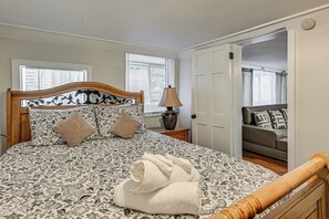 A neatly made bed with floral bedding, a bedside lamp, and a rolled towel on the floor. - 3 Mi to Dtwn! Cozy Tampa Home Base (Tampa)