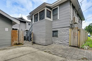 A residential building with a grey siding exterior, a wooden fence, and a stairway leading to a second-story window. - 3 Mi to Dtwn! Cozy Tampa Home Base (Tampa)