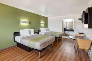 Ein Hotelzimmer mit zwei Betten, einem Schreibtisch und einem Stuhl.