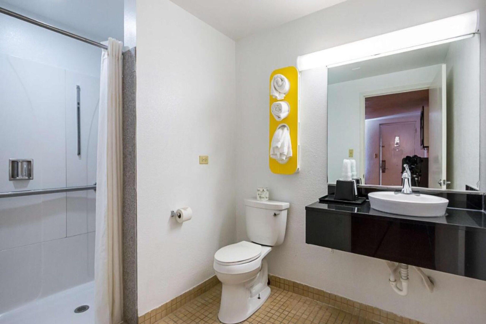 A bathroom with a toilet, a sink, and a shower area.