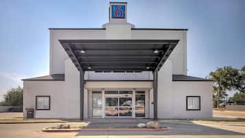 Un motel de diseño moderno, con un acceso cubierto y un letrero de número bien visible.