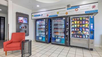 A modern interior with vending machines, a television, and a red chair.