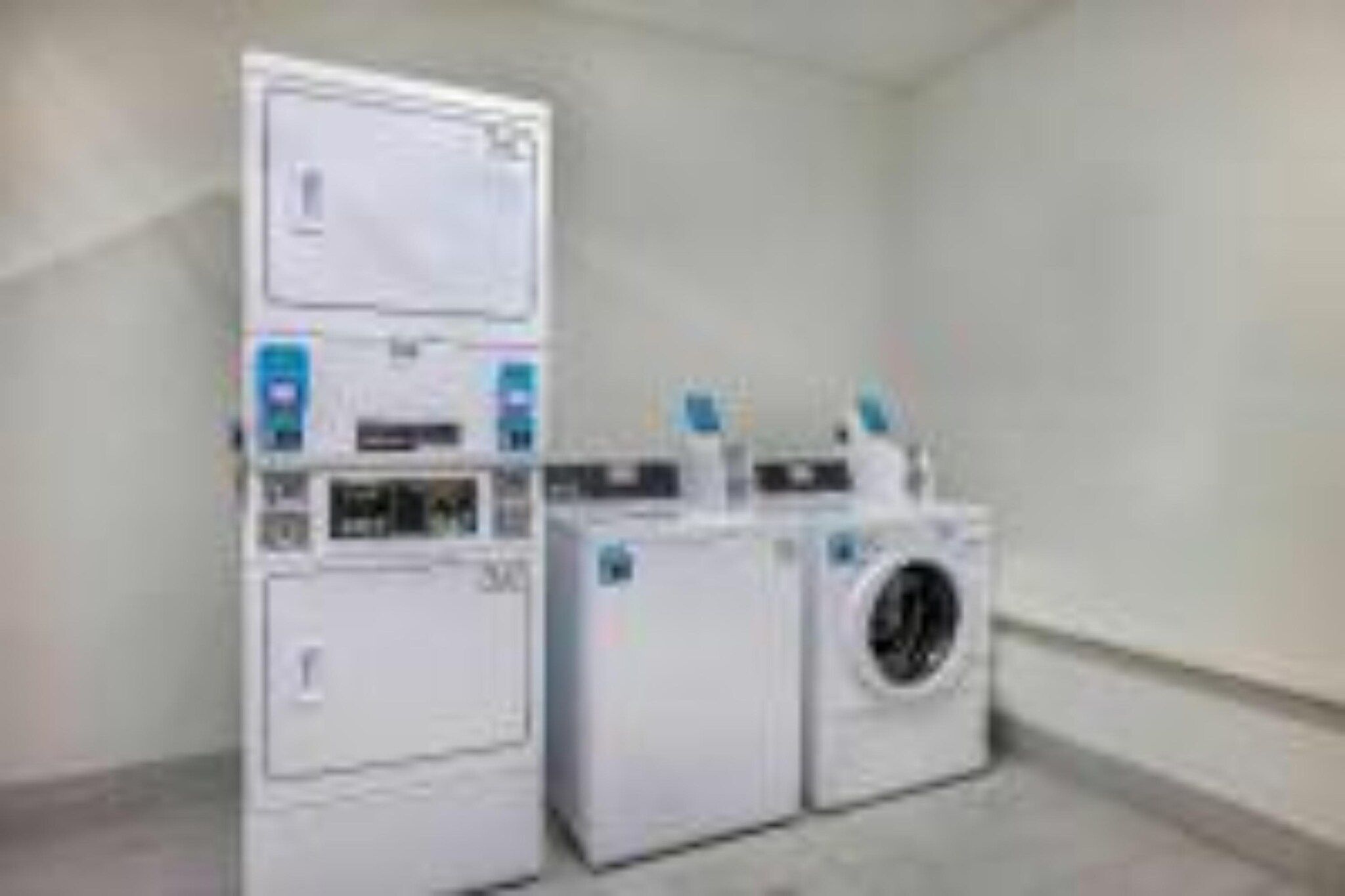 A laundry room with stacked washer and dryer units.