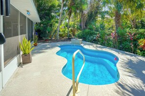 A swimming pool with a wavy edge, surrounded by a variety of plants and trees. - 4 minute walk to Private Beach Plus a Private Pool (Vero Beach)