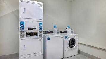 A laundry room with a stacked washer and dryer, control panels, and a digital display.