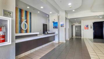 A reception area with a counter, a fire extinguisher, and a large number '6' on the wall.
