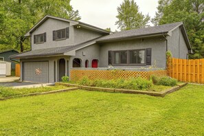 Ein zweistöckiges Haus mit Garage, umzäunter Garten und gepflegtem Rasen.