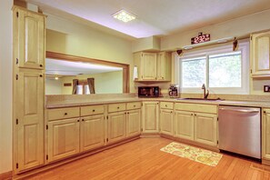 A kitchen with wooden cabinets, a microwave, a sink, and a dishwasher. - Working Travelers Welcome! Cozy New Albany Escape (New Albany)