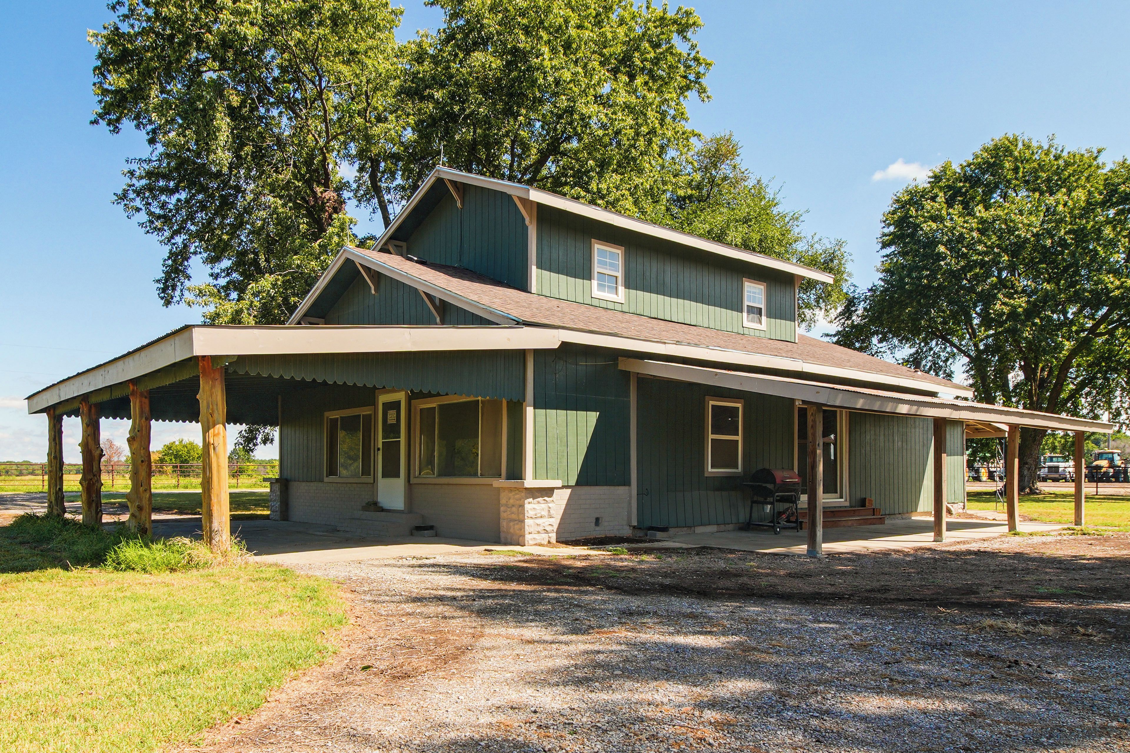 A two-story house with a porch, a garage, and a driveway.