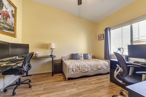 A hotel room with a bed, desk, computer, and a painting on the wall. - Tucson Extended Stay Overlooking Kitt Peak (Tucson)