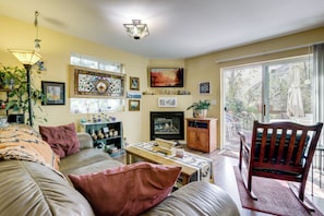 A cozy living room with a sofa, a television, and a bookshelf. - Creekside New Castle Townhome w/ Scenic Deck (New Castle)