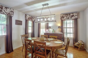 A dining area with a round table, chairs, a chandelier, and a view of the outdoors through windows. - 3 Mi to Dtwn Blue Ridge! Family Home w/ Fire Pit (Blue Ridge)