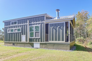 Ein zweistöckiges Haus mit einem Metall-Dach und großen Fenstern.