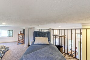 Quarto com cama, janela e varanda.