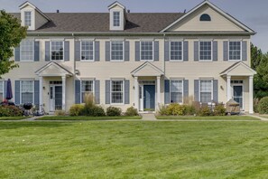 A two-story building with a symmetrical facade, multiple windows with shutters, and a central entrance. - Shakopee Townhome Near Valleyfair & Mystic Lake (Shakopee)