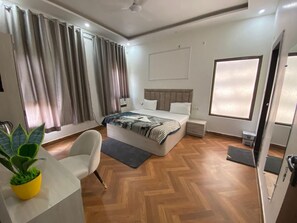 Un dormitorio moderno con cama, mesitas de noche, un escritorio y una planta en maceta.