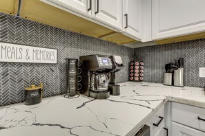 A kitchen with a coffee machine, a sign reading 'Meals & Memories,' and a herringbone-patterned backsplash. - Game Room & Private Yard! Family Houston Escape (Houston)