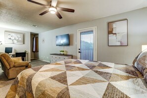 A bedroom with a bed, a ceiling fan, a television, a dresser, and a door with blinds. - Game Room & Private Yard! Family Houston Escape (Houston)