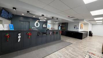A reception area with a counter, a number six sign, and holiday decorations.
