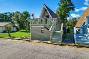 A small, single-story building with a balcony and a staircase leading to a deck. - Sun-Kissed Cottage: Lake Access, 14 Mi to Disney (Clermont)