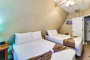 Une chambre d’hôtel avec deux lits, un luminaire au plafond, un tableau accroché au mur et une porte portant l’inscription « Chambre privée réservée aux propriétaires ».