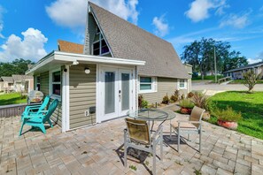 A house with a covered patio, a barbecue grill, and outdoor seating. - Sun-Kissed Cottage: Lake Access, 14 Mi to Disney (Clermont)